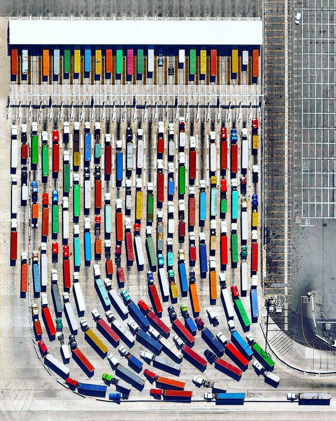 “Long-haul trucks wait in line to exit the Port of Los Angeles in California. It is estimated that there are approximately 3.5 million truck drivers in the United States and they drive nearly 140 billion miles on American highways every year. In total, 433 billion miles are covered annually by the entire population.”