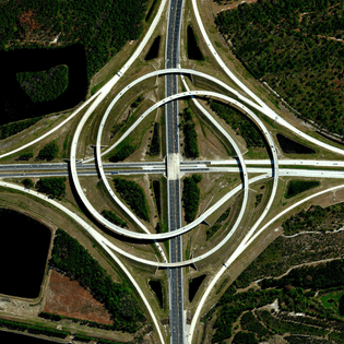 “A turbine interchange connects the SR 9A and SR 202 in Jacksonville, Florida, USA. Also known as a whirlpool interchange, this structure consists of left-turning ramps sweeping around a center interchange, thereby creating a spiral pattern of right-hand traffic. This type of junction is rarely built, due to the vast amount land that is required to construct the sweeping roads.”