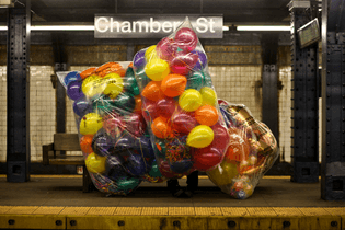 A balloon delivery man waiting for the subway at Chambers St., New York. January 2011. Credit Fred R. Conrad/The New York Times