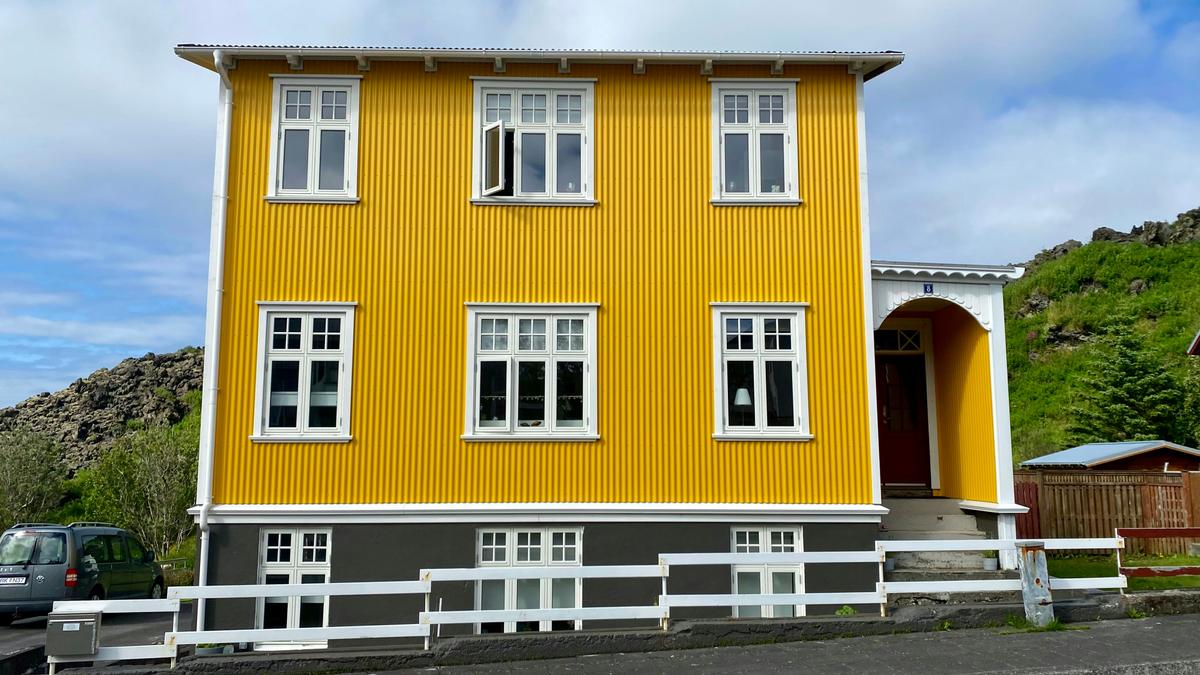 2022-07-26_a-yellow-house-with-a-fence-bvetfshwg4g.jpg