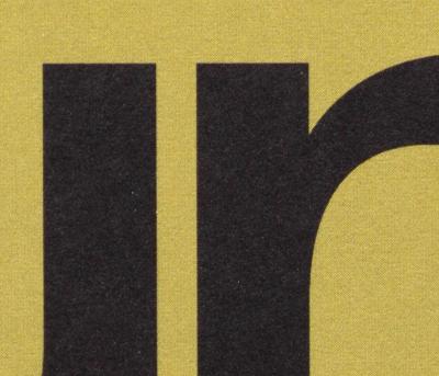 Business card detail with visible 4-color halftone grid of black typography on green-yellow background.