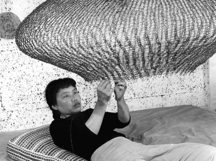Ruth Asawa forming a looped-wire sculpture in 1957.