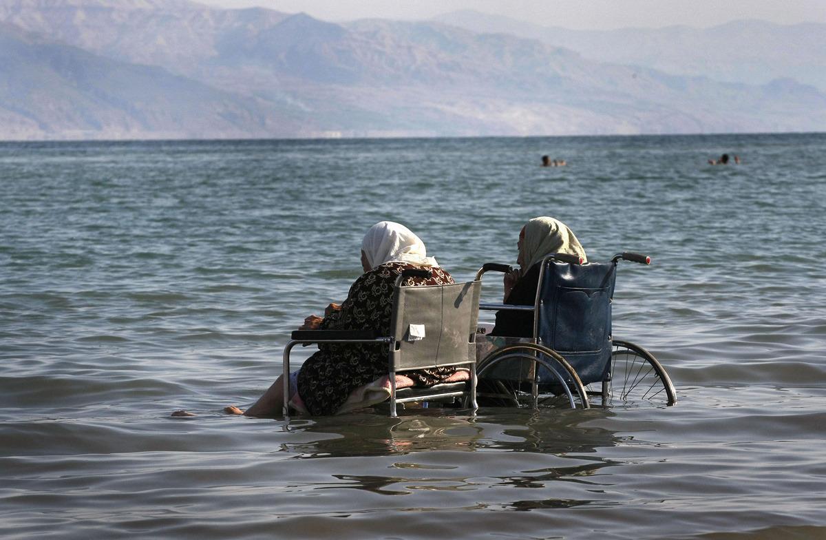 Elderly Palestinian women sit in wheelchairs as they enjoy the waters of the northern part of the Dead Sea, in the West Bank, on October 2, 2008.