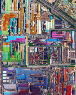 “Colorful, metal-roofed industrial buildings line the coast of Tokai, Japan. The city’s economy is dominated by a massive steel mill - a portion of which is seen at the bottom of this Overview. Nippon Steel, the company that owns the mill, has an annual production of more than 47 million tons of steel across its various facilities. Steels - consisting of alloys of iron and other elements, primarily carbon - is a major component in buildings, infrastructure, tools, ships, automobiles, appliances, and weapons.”