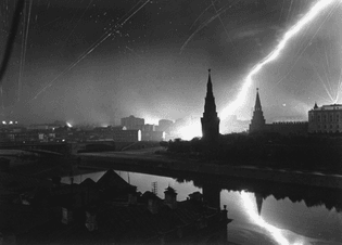 Margaret Bourke-White - Overall view of central Moscow with antiaircraft gunners dotting sky over Red Square with exploding shells, with spires of Kremlin silhouetted by a German Luftwaffe flare. July 26, 1941