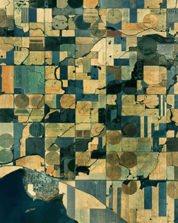 “An extensive patchwork of farmland is seen here in Pondera County, Montana, USA. Located on the eastern edge of the Rocky Mountains less than 50 miles (80 km) south of Canada, the county averages fewer than 4 people per square mile. In the bottom left corner of this Overview is the town of Valier — population 509 — where agriculture and cattle ranching are the main industries.”