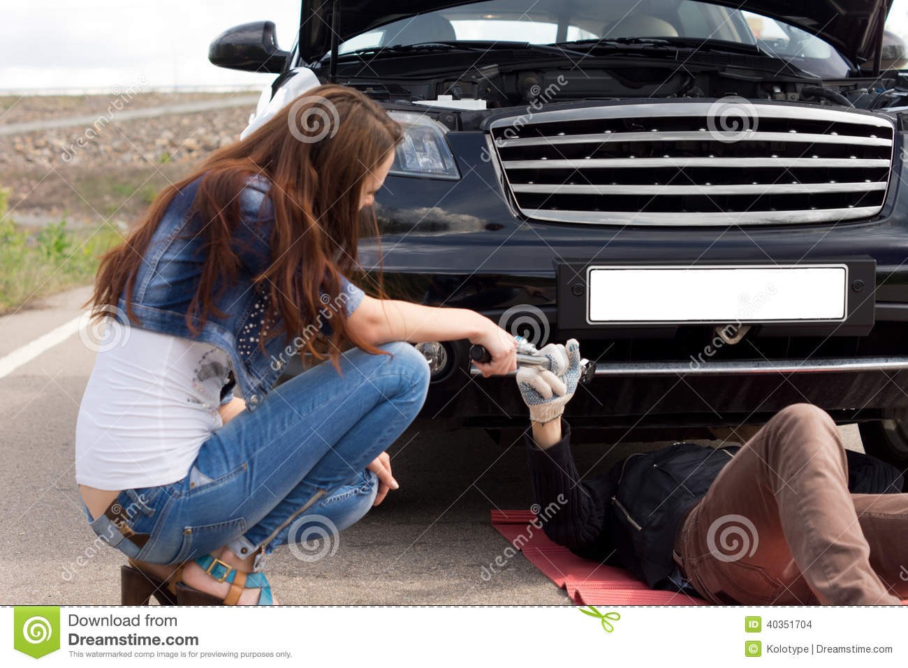 She fixes cars. Девушка чинит машину. Девушки чинят автомобиль на обочине. Женщина помогает отремонтировать автомобиль.