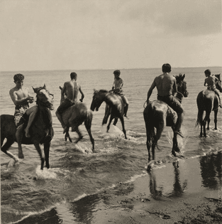 Men on horseback run through the surf in Tahiti, 1922. Photograph by Edward Burton MacDowell, National Geographic Creative