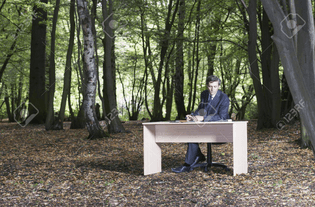19079020-business-man-sitting-at-desk-in-middle-of-forest-working.jpeg