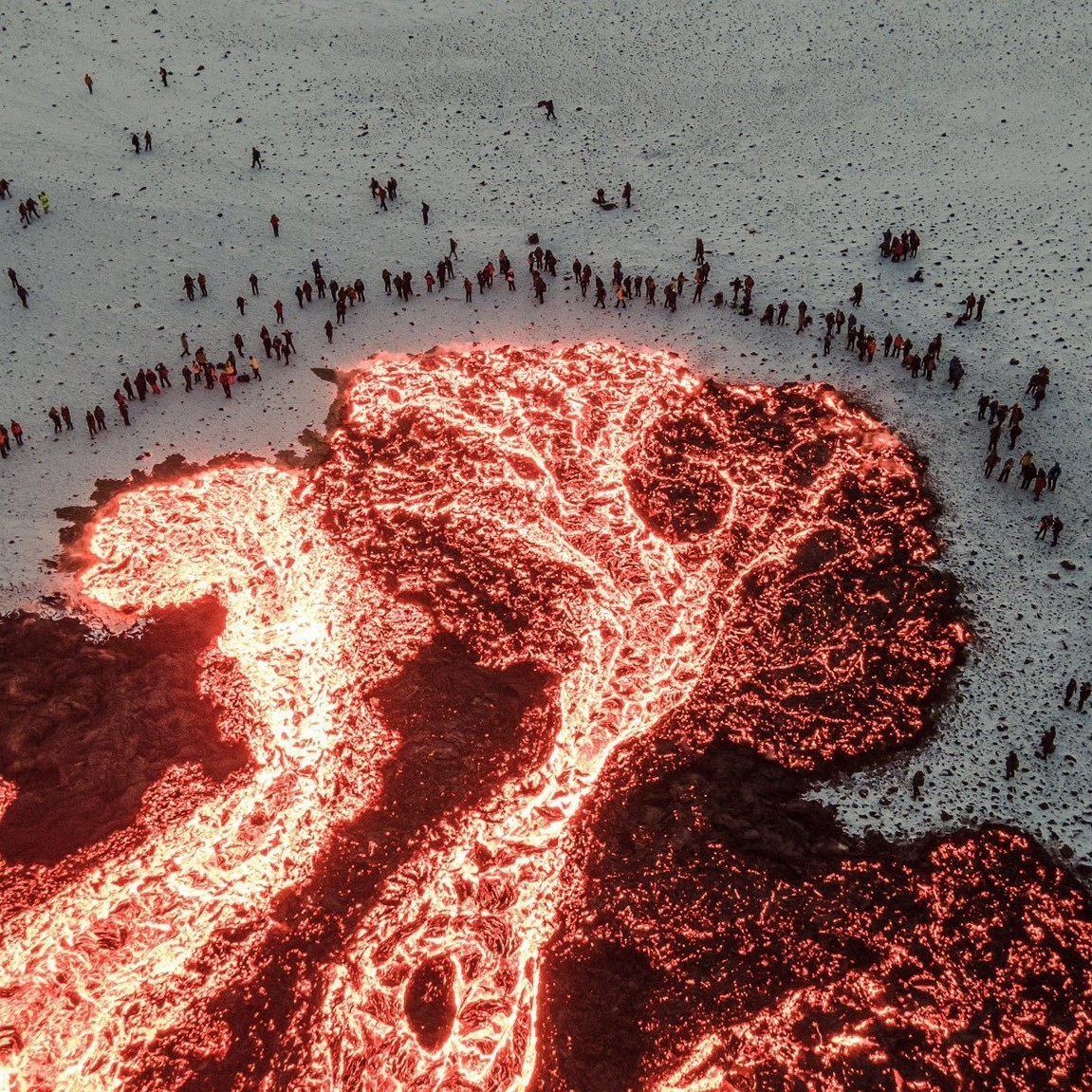 People gathered around lava, Iceland.