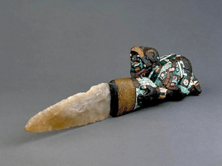 Aztec/Mixtec sacrificial knife depicting a crouching eagle warrior holding a flint blade, bound together with agave fiber and resin. Circa 1400 - 1521.