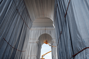 Workers wrap the Arc de Triomphe