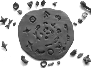 072. stamping of ceramic talisman on clay disc. made as ornament for the anthropocene layer of geostrata