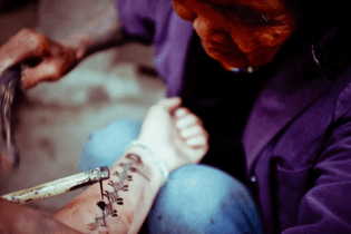Apo Whang-od applying a snake (tabwhad) tattoo
