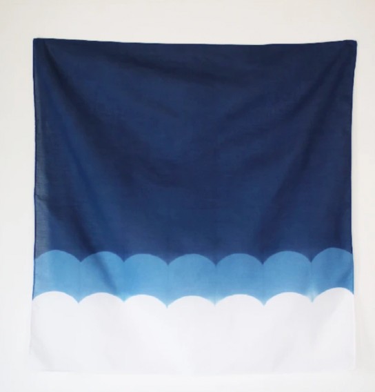A Japanese indigo-dyed cloth in dark blue, with a light blue and white scallop pattern “waves”.