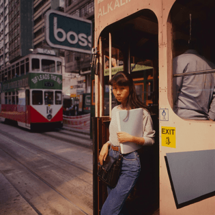 A photo shot in 1990 shows a Hong Kong woman getting off a tram in Central. Photo: Greg Girard