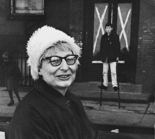 Jane Jacobs, May 4, 1916 – April 25, 2006.

With her son Ned in front of a Greenwich Village building, designated for demolition by the City Planning Commission, 1961; photograph by Ruth Orkin.