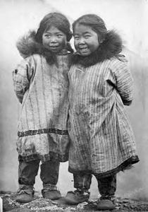 Two Iñupiat girls wearing print cotton parkas, between 1903 and 1910