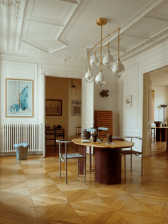 In the dining room of Sophie Dries and Marc Leschelier’s Paris apartment, a pendant light by Dries for Kaia hangs above a table of her design topped with a Charlotte Perriand lamp.Credit...
