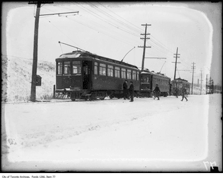 100 years ago streetcars to Port Credit wait at a terminus just east of the Humber River. Travellers coming from downtown made a snowy switch here from the TTC to a suburban line run by Hydro-Electric Railways.