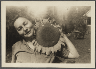 Photograph of Genevieve Taggard with a sunflower inflorescence