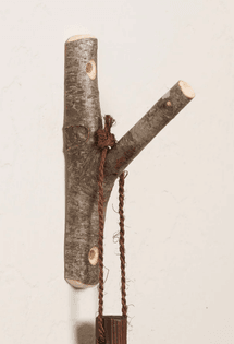 A tree branch being used as an indoor hook.