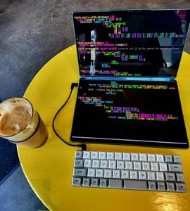 A Yoga Book 9i dual screen laptop running emacs, with a Vortex Core 40% keyboard