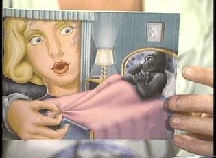  [A close shot of a greetings card, in which a gorilla in bed is clutching his bed sheets in modesty, as the enormous head of a blond woman peers curiously through the window. A King Kong reversal.]
