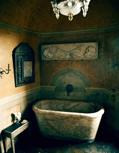 Axel Vervoordt. An 18th-century Italian bath, Roman frieze and 1680 French mirror in a bathroom.