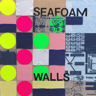 a 6x6 inch collage on some cardboard, with yellow, pink, and green stickers scattered throughout the grid. some squares and strips of white and light-blue fabric are interspersed, at times overlaid with film transparencies. the band name "SEAFOAM WALLS" is arranged at the top and bottom of the composition in vinyl lettering.