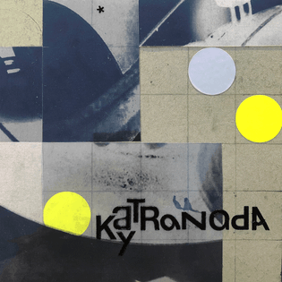 A 6x6 inch collage: some yellow and silver circle stickers, film transparencies, and vinyl letters that read "KayTRaNadA" on a gray-blue grid.