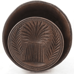 A circa-1850 to 1880 plunger-type butter mold with a sheaf of wheat design.