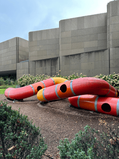 a red and yellow, colorful, twisting, tubular play sculpture designed by Yvan Pestalozzi in 1972