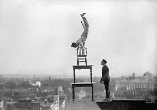 Jammie Reynolds, balancing on the on chairs on the edge of a rooftop in Washington, DC ca. 1917