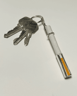 a keychain made out of metal that has the shape to hold one ciagrette inside.