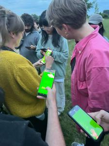 people holding their phones out with a green website on it