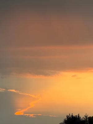 A photo of a blue sky with some clouds and rays of sun