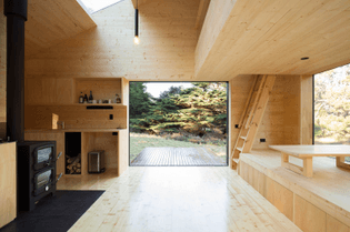 the-open-plan-interior-has-been-sheathed-in-light-colored-wood-to-create-a-sense-of-enclosure-as-well-as-an-escape-from-the-...