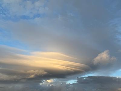 A photo of a blue sky with some clouds and rays of sun
