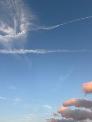 A photo of a blue sky with some clouds and rays of sun